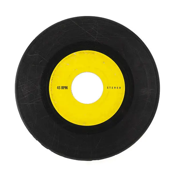 Photo of Yellow and black 45 music record with scratches