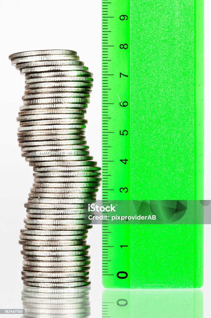 Coins stacked together being measured by a ruler Measuring coins  Growth Stock Photo