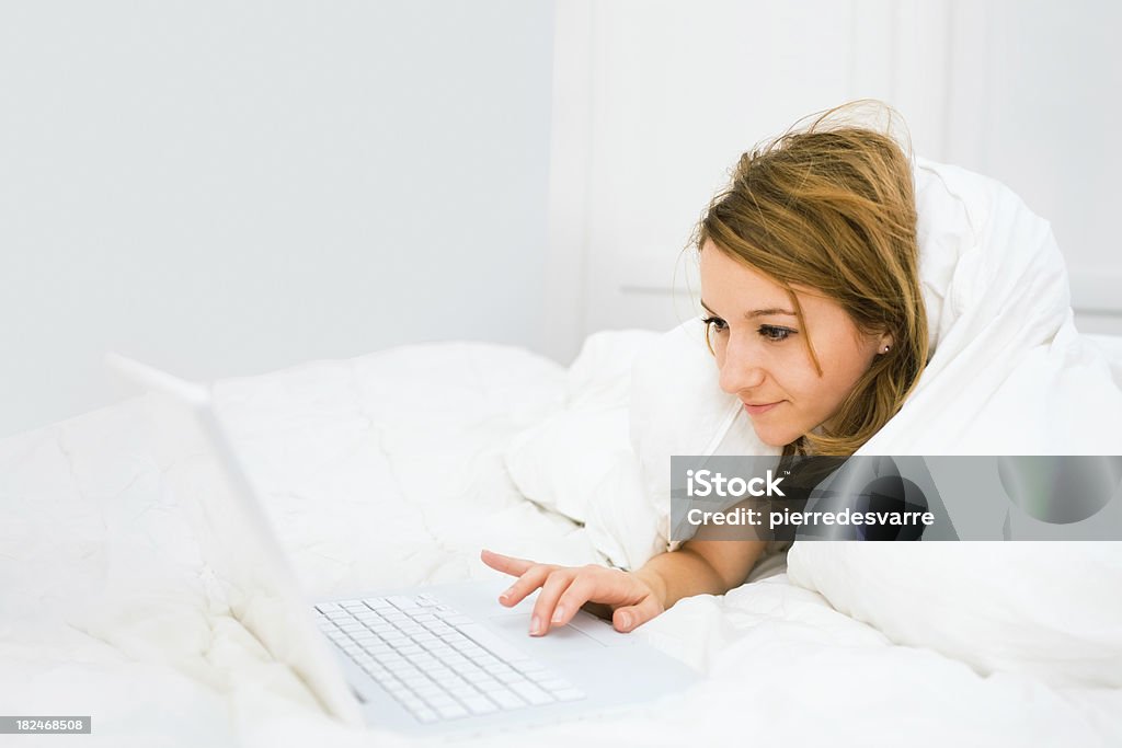 Молодая женщина с ноутбуком утро кровать-скопировать пространства Ярко освещённый - Стоковые фото 20-24 года роялти-фри
