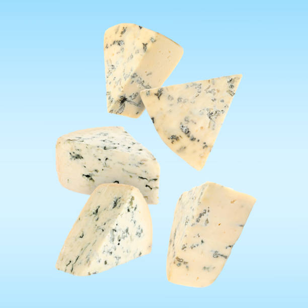 istock Pieces of tasty cheese falling on light blue background 1824685258