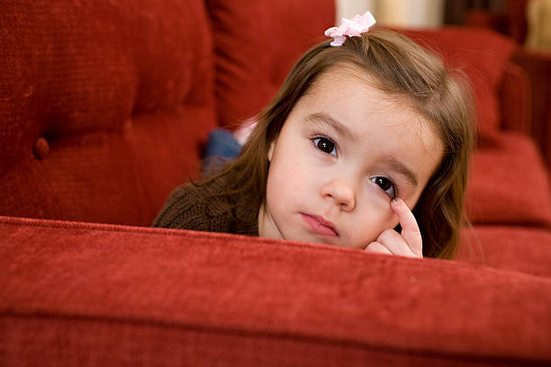 istock young girl laying on a red couch 182468559