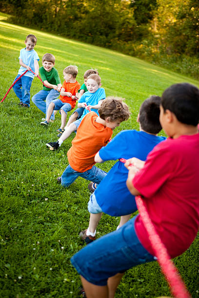 Happy Young Boys Playing Tug-of-War Outside