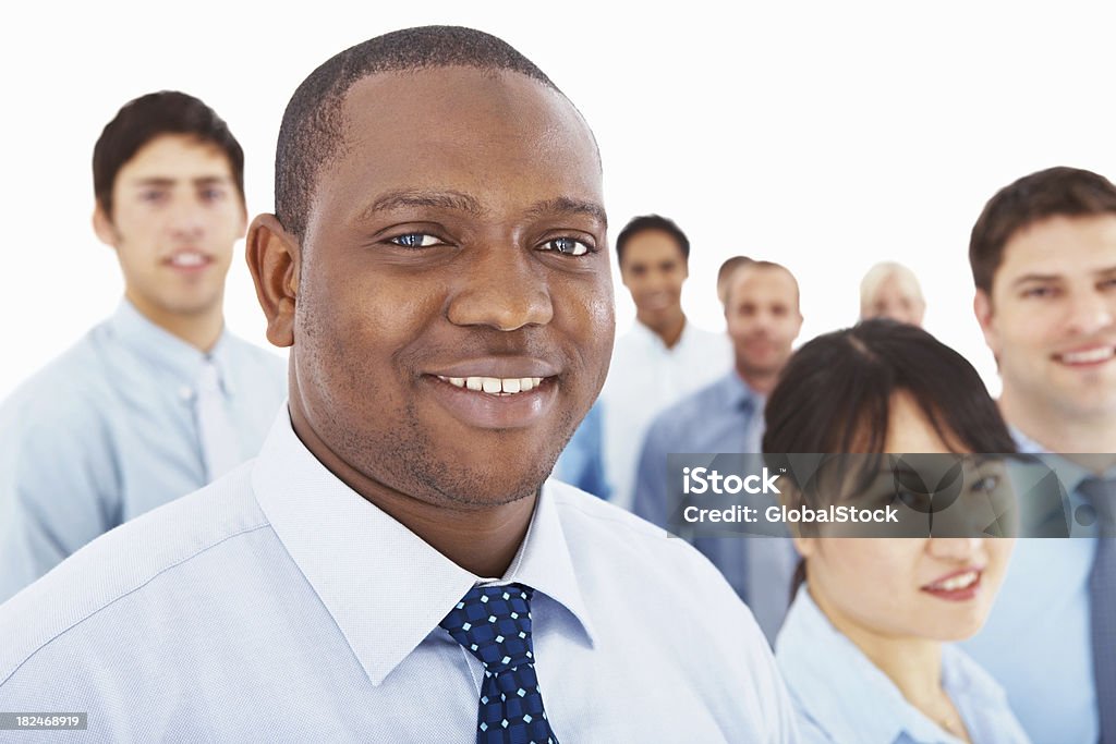 African American business man with colleagues at the back Closeup of a happy African American business man with colleagues at the background 20-24 Years Stock Photo