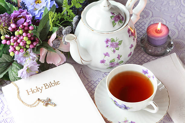 Lovely teapot and tea cup with violets with Bible and candle ready for meditation time.
