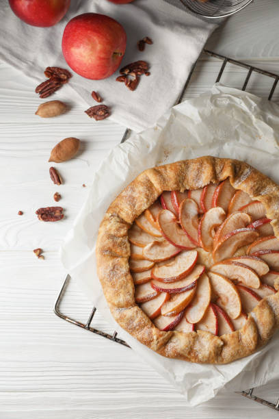 istock Delicious apple galette and pecans on white wooden table, flat lay 1824702275