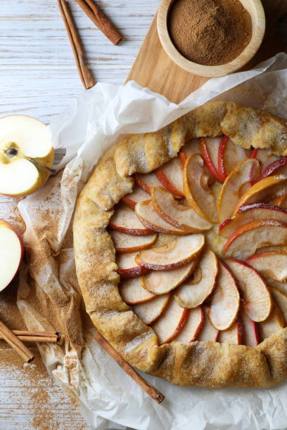 istock Delicious apple galette and cinnamon on white wooden table, flat lay 1824703404