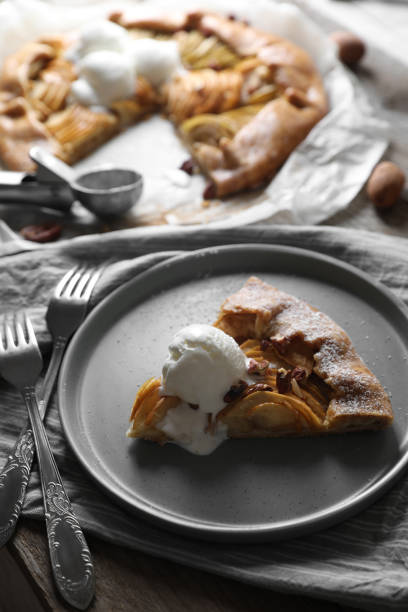 istock Delicious apple galette served with ice cream on wooden table 1824704503