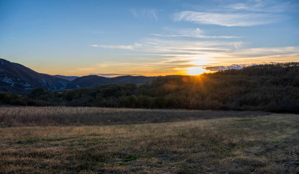 istock Sunset over the mountain. The sun's rays fall on the plowed fields and on the forest at the bottom of the mountain. 1824705586