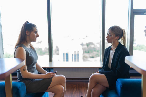 istock Women spend time together sitting near window during break 1824708425