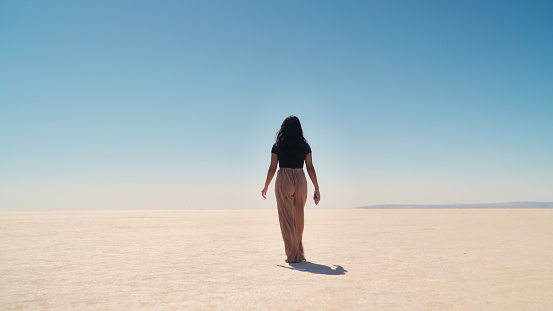 A multiracial female tourist is walking and exploring the Tuz Gölü Salt Lake in Anatolia region of Türkiye Turkey.