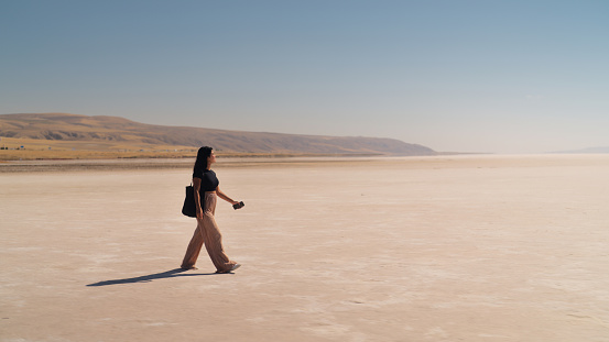 A multiracial female tourist is walking and exploring the Tuz Gölü Salt Lake in Anatolia region of Türkiye Turkey.