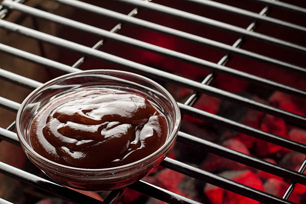 Barbecue Sauce A bowl of BBQ sauce on the grill. barbeque sauce photos stock pictures, royalty-free photos & images