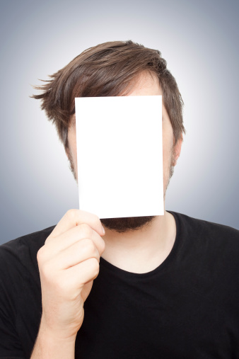 Caucasian young man holding a white card in front of his face.Similar images: