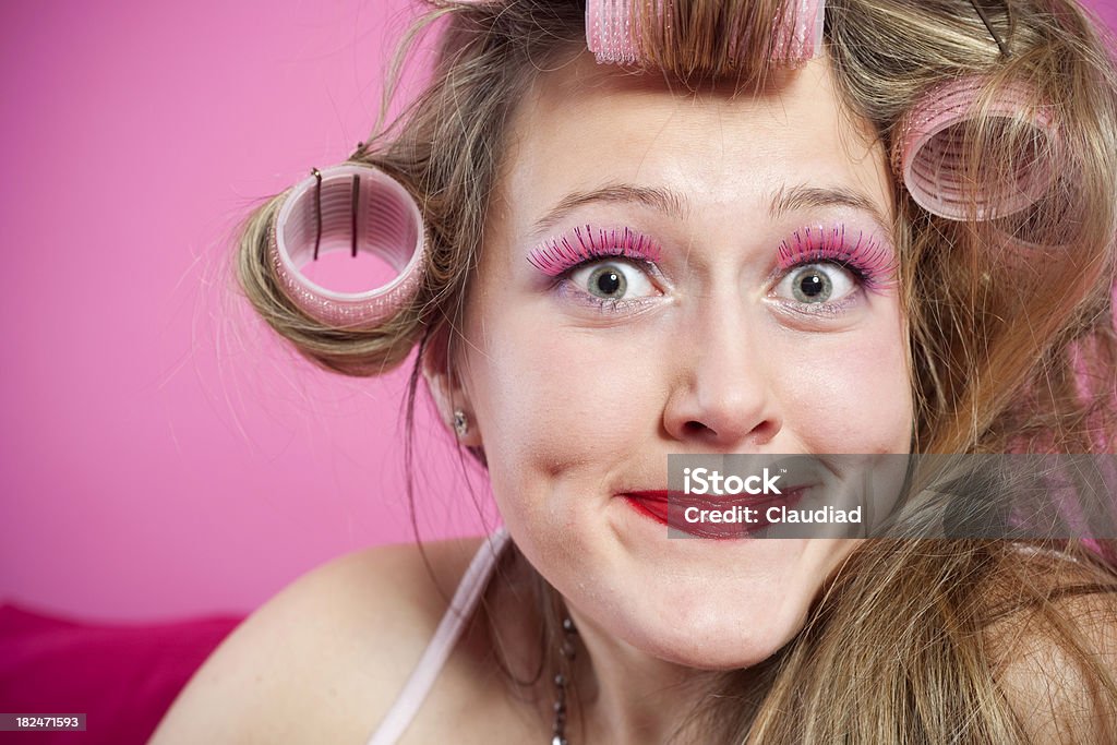 Young crazy woman with curlers Smiling young woman relaxing on pink couch.More of this model 20-24 Years Stock Photo