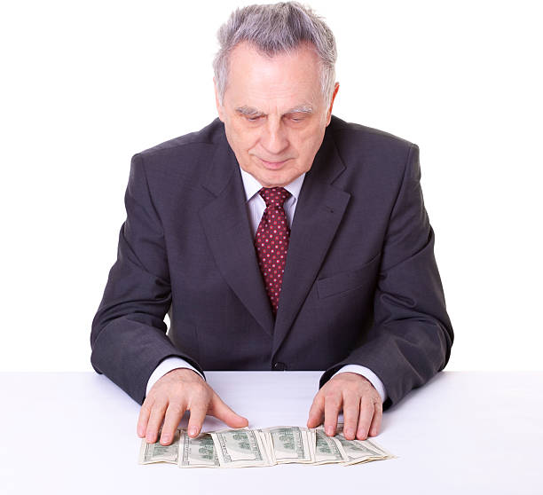 istock senior businessman with dollars 182471733