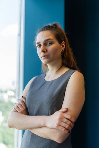 istock Young woman with high ponytail poses against window 1824717416