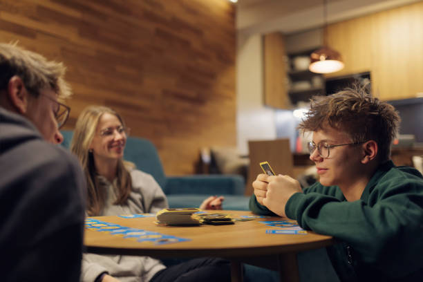istock Teenagers playing card game at home 1824718568
