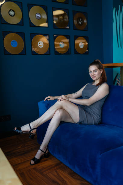 istock Young woman with bare legs poses for photo sitting on sofa 1824719213