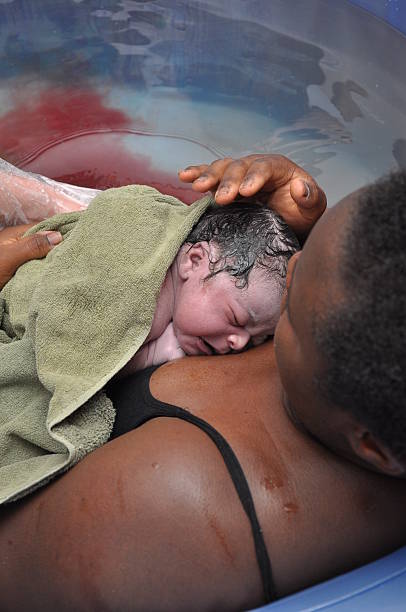 Baby Day~Water Birth; Mother and Newborn mother comforts baby only seconds old water birth stock pictures, royalty-free photos & images