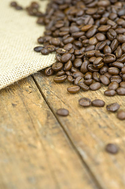 Coffee beans scattered on wood floor stock photo