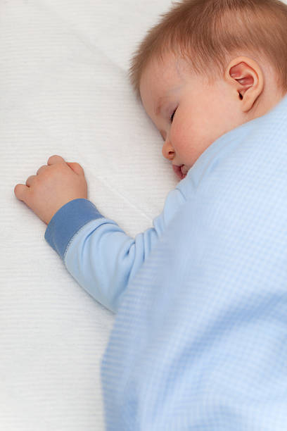 istock 8 month old baby boy sleeping peacefully in his bed. 182472357
