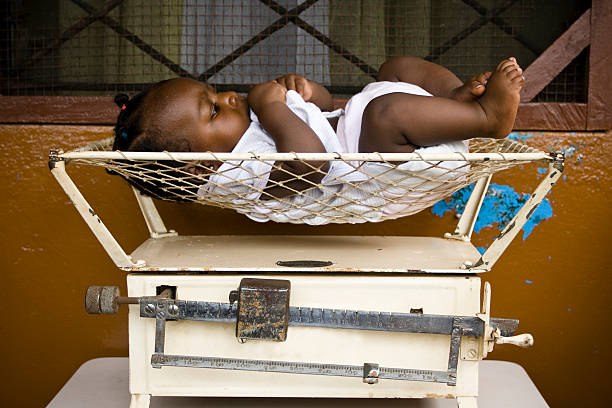 mother in birthing tub examines newborn's feet