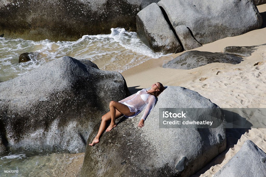 Mujer tomando el sol en la ciudad de boulder en Virgen Gorda, BVI - Foto de stock de Biquini libre de derechos