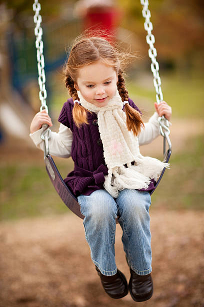 menina balançando no parque em um dia de outono - little girls autumn child red hair - fotografias e filmes do acervo