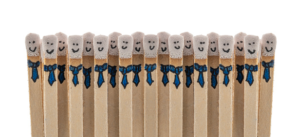 matchsticks with faces painted on the heads on white background