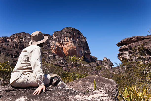 istock Pensive woman sitting on a rock 182473438