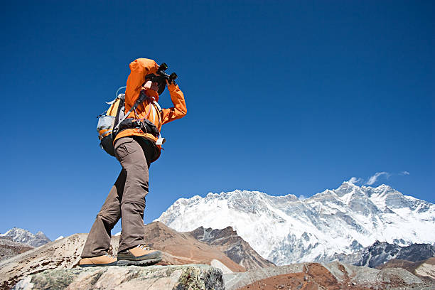 istock Female trekker looking through binoculars, Lhotse in background. 182473446