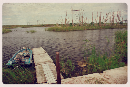 Retro-styled postcard of a motorboat and wooden dock in Florida's Everglades.