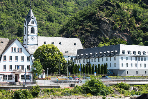 View from the river Rhine at the East bank with the pilgrimage location Wallfahrtskloster in Kamp-Bornhofen. The convent for Franciscan friars dates back to the 17th century.