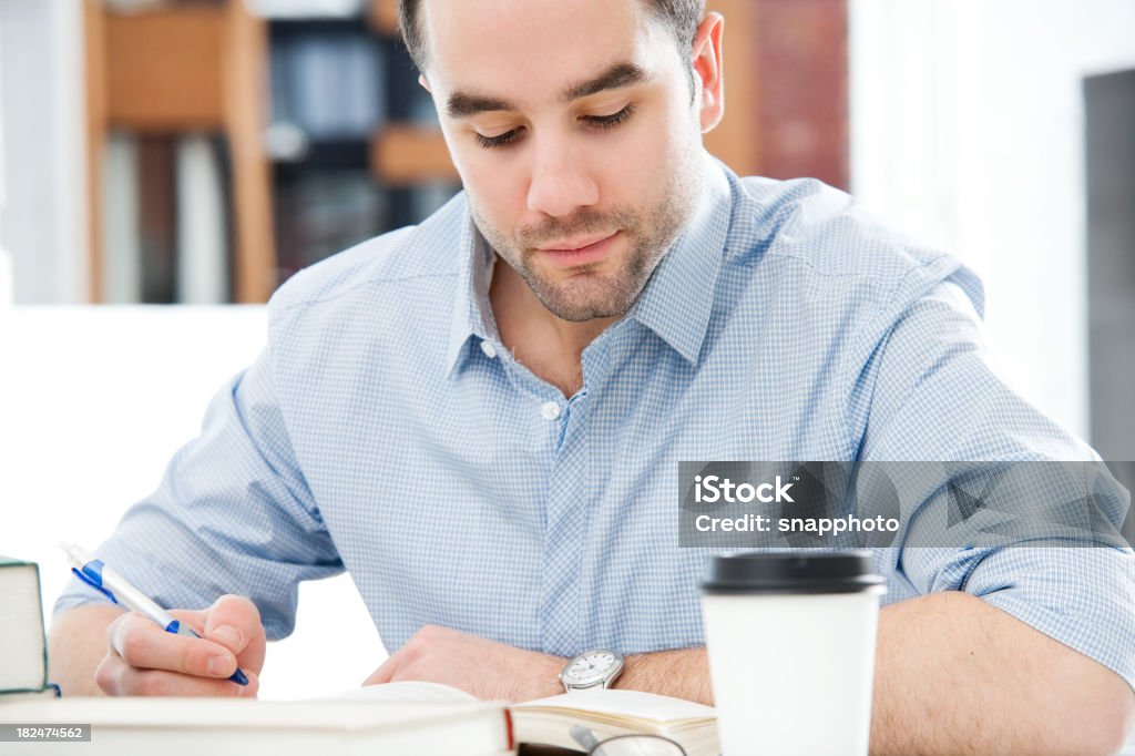 Low depth photo of a man working at his desk with coffee people 25-29 Years Stock Photo