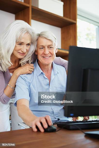 Senior Couple Using Computer At Home Stock Photo - Download Image Now - 50-59 Years, 55-59 Years, 60-64 Years