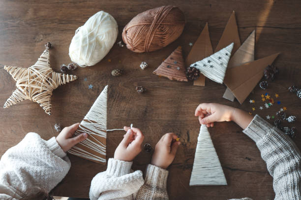 Children making Christmas decorations from yarn