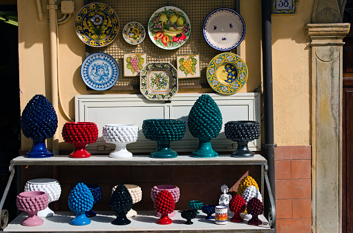 Santo Stefano di Camastra, Italy-October 27,2023:Detailed view shelves with different colorful vases, jugs, plates. Gift shop in the street of Santo Stefano di Camastra village.