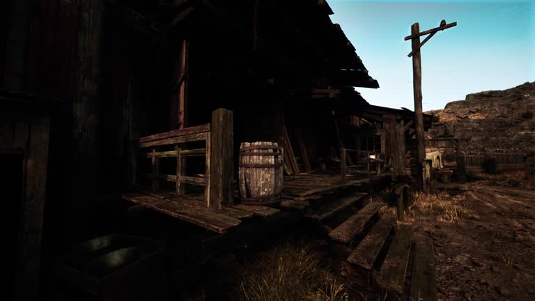 An antique wooden building with a rustic barrel beside it