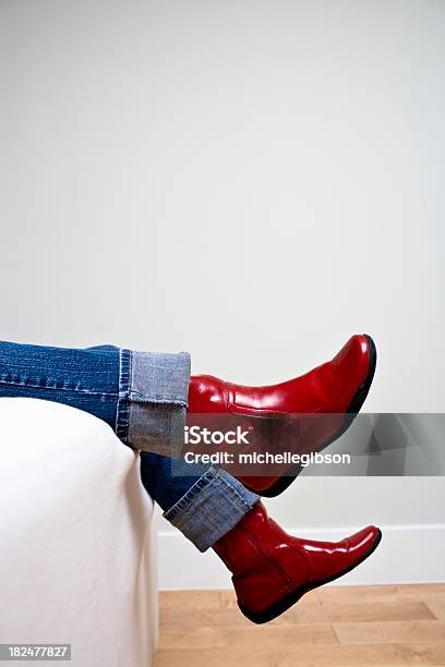 Photo libre de droit de Une Femme Sagiter Jambes Portant Ourlets De Jeans Et Chaussures Rouges banque d'images et plus d'images libres de droit de Canapé