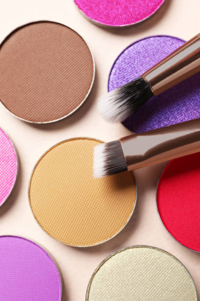 istock Different beautiful eye shadows and makeup brushes on beige background, flat lay 1824779986