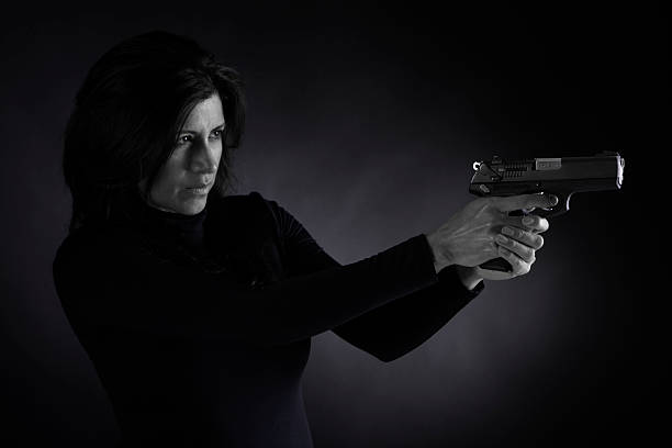 istock Women with gun on black background 182478052