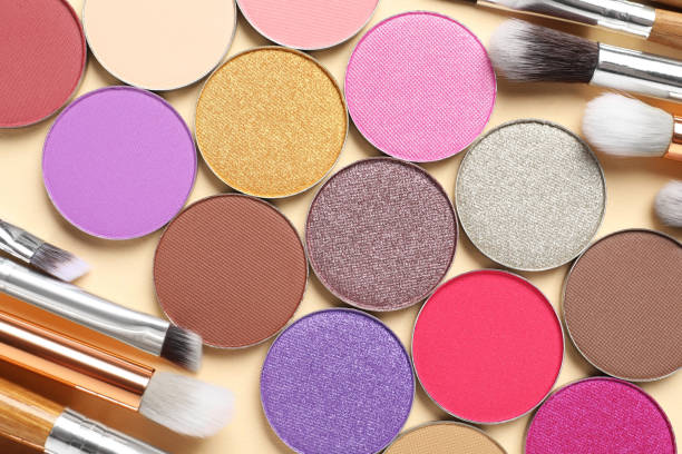 istock Different beautiful eye shadows and makeup brushes on beige background, flat lay 1824781624