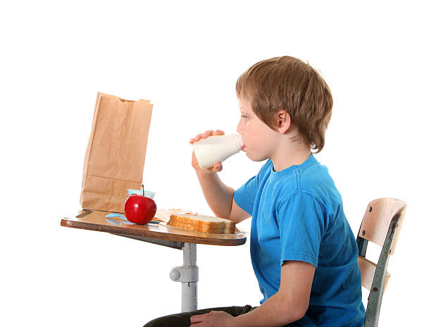 niño bebiendo leche - packed lunch paper bag apple lunch fotografías e imágenes de stock