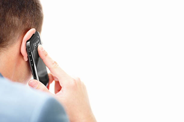 Trendy man wearing yellow hoddie talking on the phone and showing ok sign over yellow background. Smartphone. Stylish man.