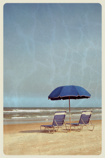 Retro-styled postcard of two beach chairs and an old-fashioned wooden beach umbrella at the water's edge.