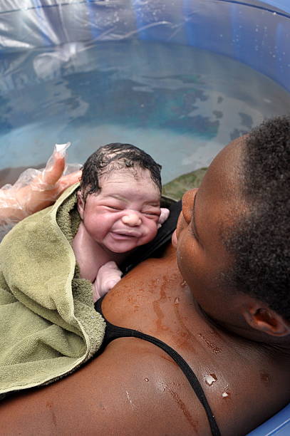 Baby Day~Water Birth; Mother and Newborn twenty seconds old, newborn and mother meet face-to-face (part of a series of the event) water birth photos stock pictures, royalty-free photos & images