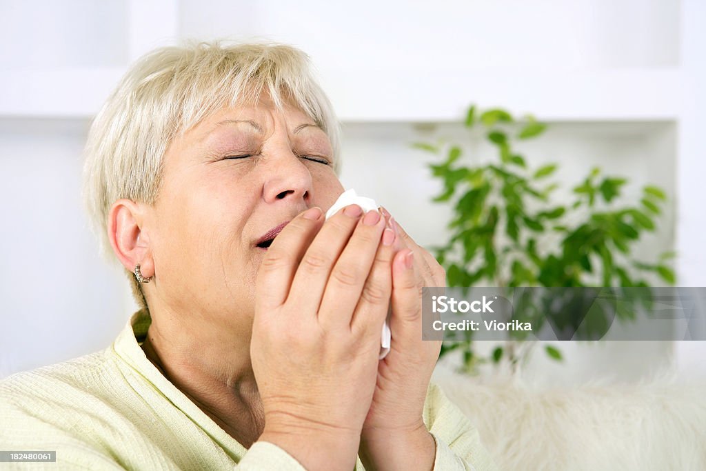 Sênior mulher sneezing - Foto de stock de 50 Anos royalty-free
