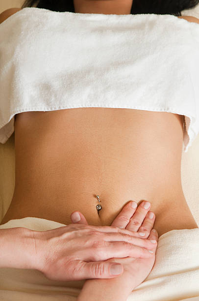 woman receiving lymphatic massage on abdomen stock photo