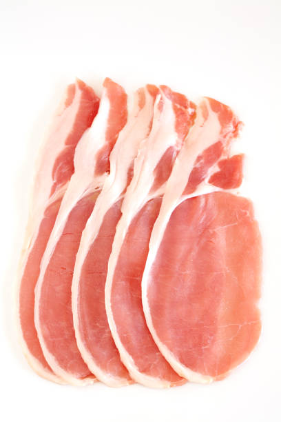 Five slices of uncooked bacon on white background stock photo