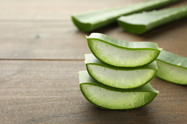 istock Fresh aloe vera pieces on wooden table, closeup. Space for text 1824813090